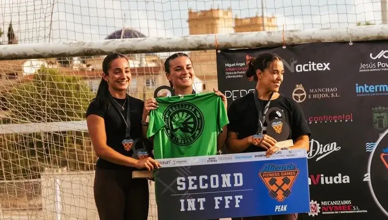 Tres atletas en un podio de Atlantic Fitness Games con la camiseta de Crossbox Almansa